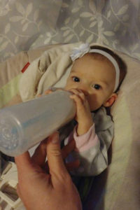 feeding a bottle to an infant girl