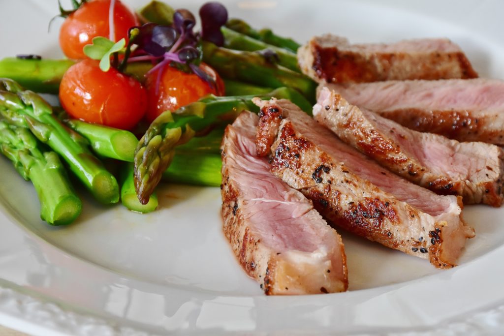 Trying to find a mom diet plan sucks, but not when you are looking into this diet!
steak cut into slices with asparagus and cherry tomatoes on the plate