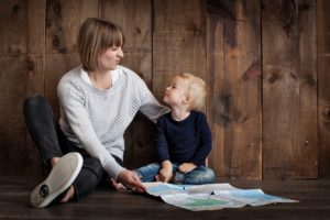 photo of mom and young boy sitting on the floor looking at each other