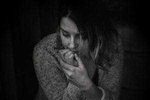 black and white photo of a woman with her elbows on her knees and chin in her hand