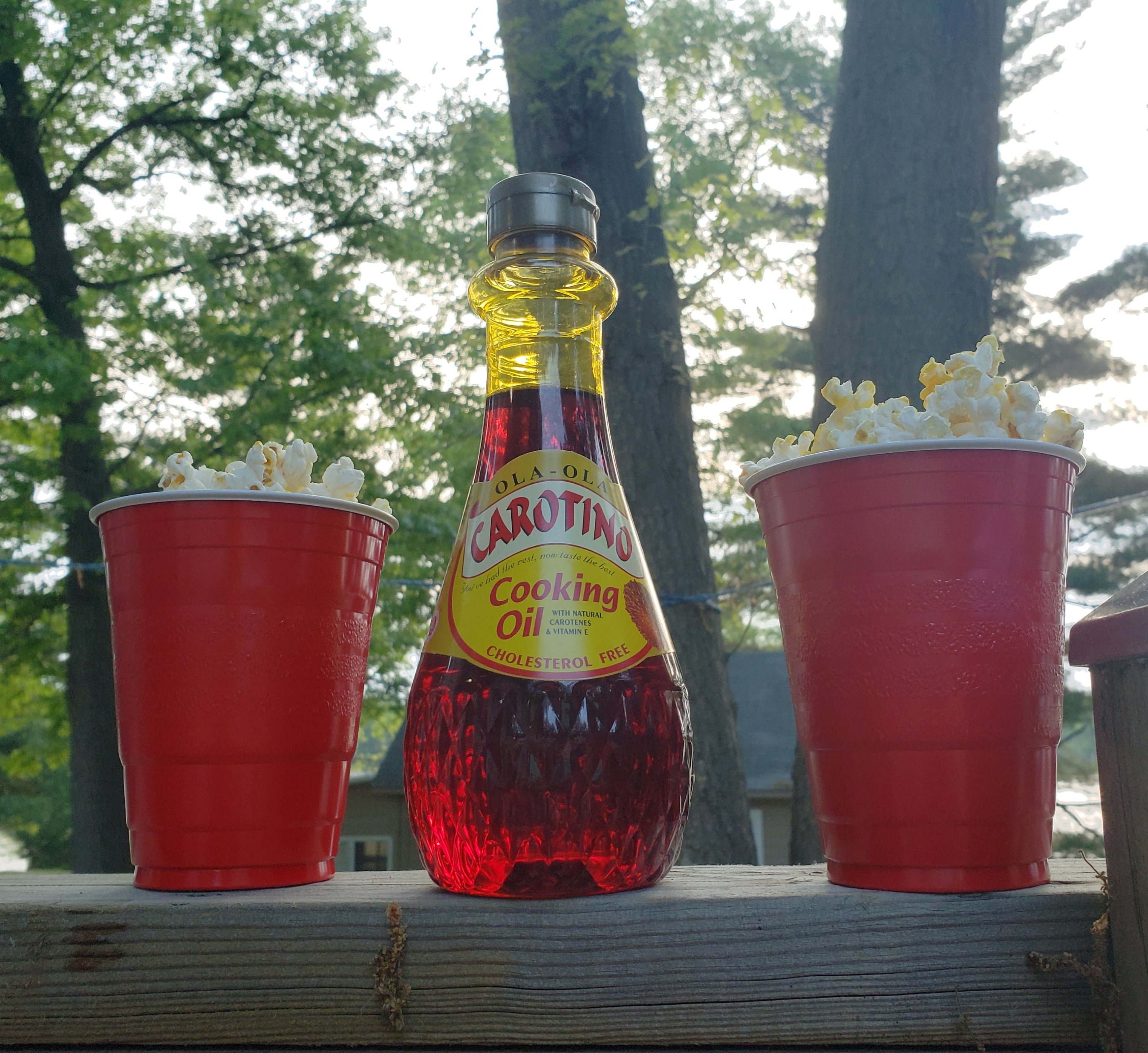 cooking oil between two red solo cups filled with popcorn