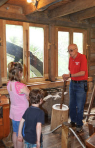 man demonstrating how the mill works for kids