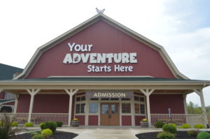 Barn style store front with "Your Adventure Starts Here" on the front of it