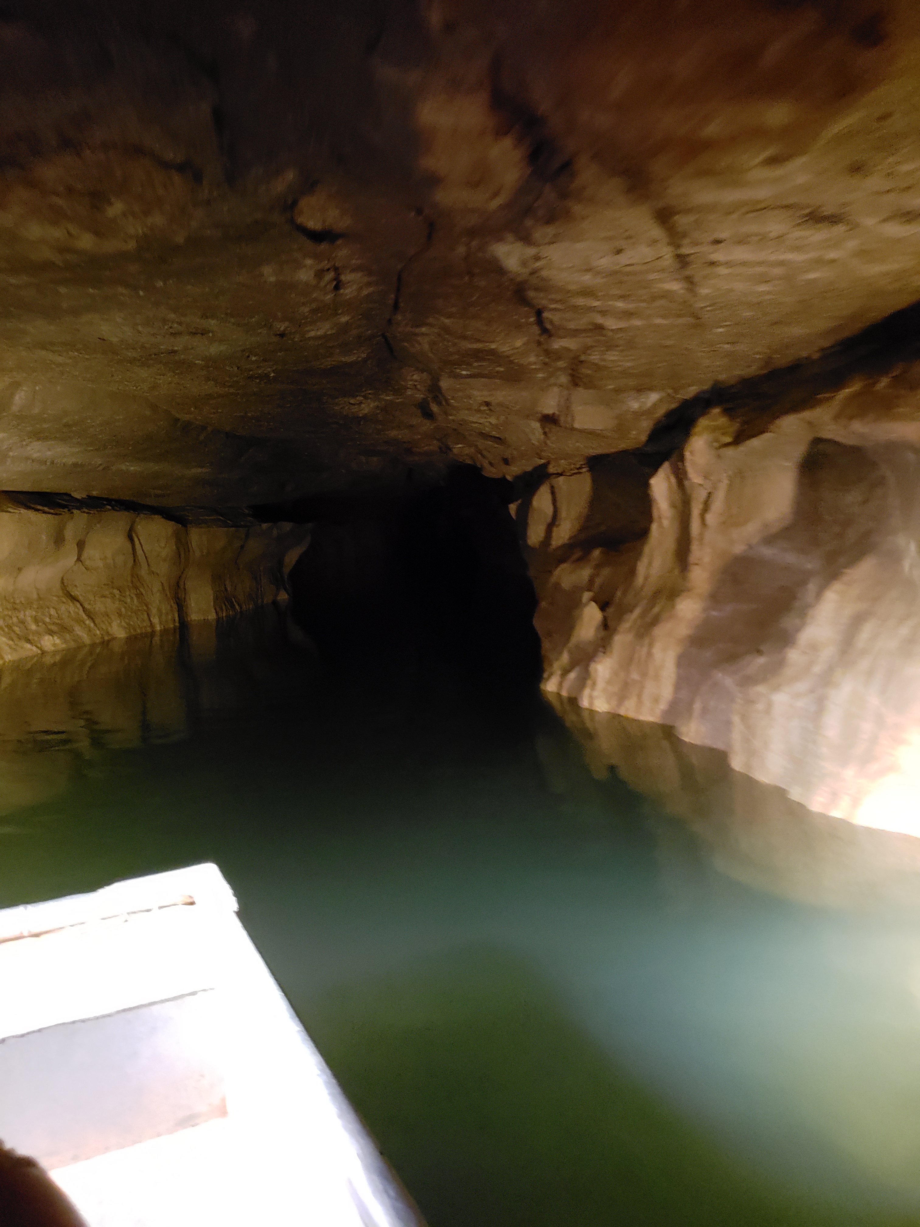 Photo of river flowing into a dark cavern at Bluespring Caverns tour