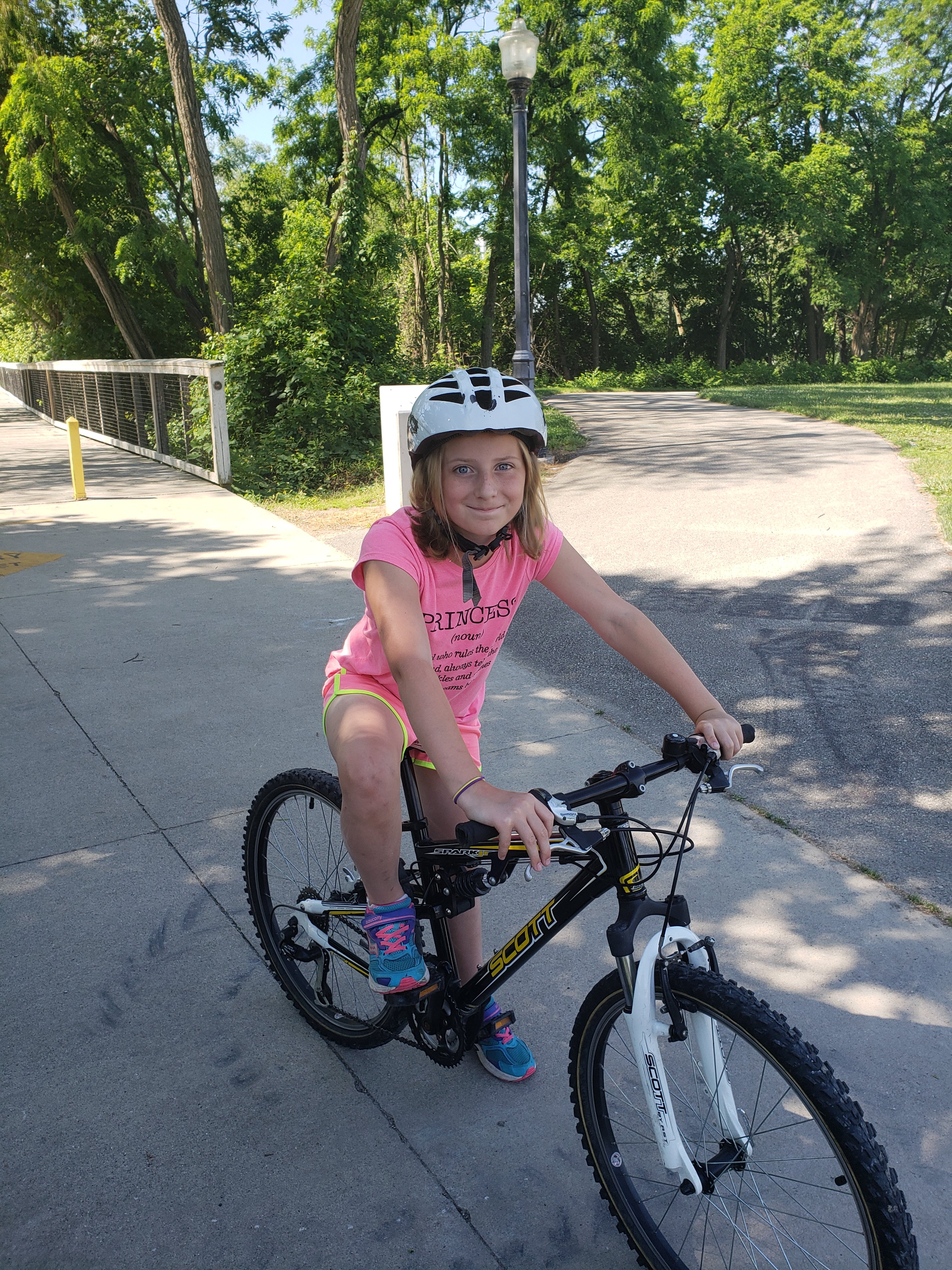 girl on a bike wearing a helmet on a beautiful trails around Fort Wayne