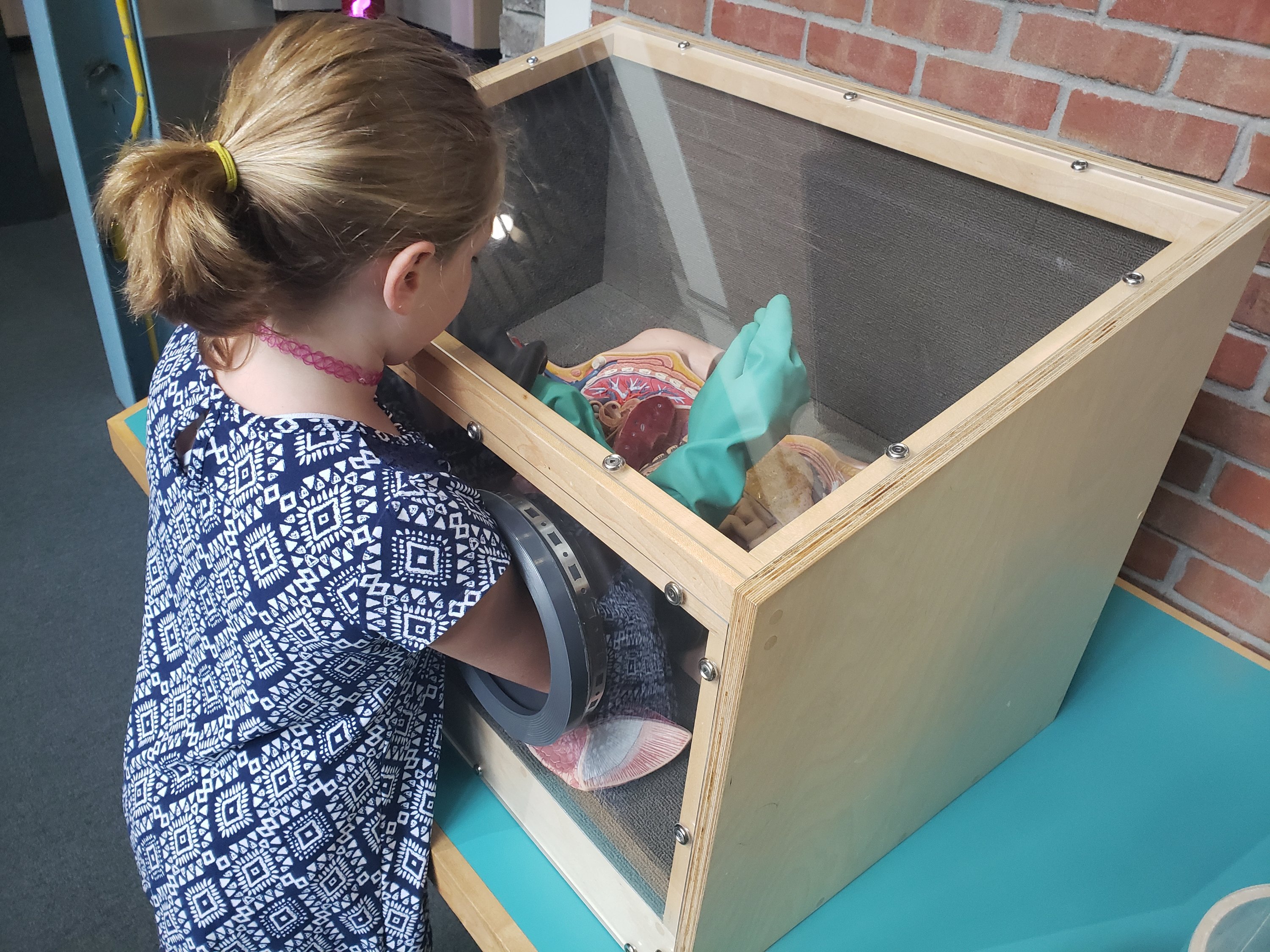 a girl standing at an interactive table 