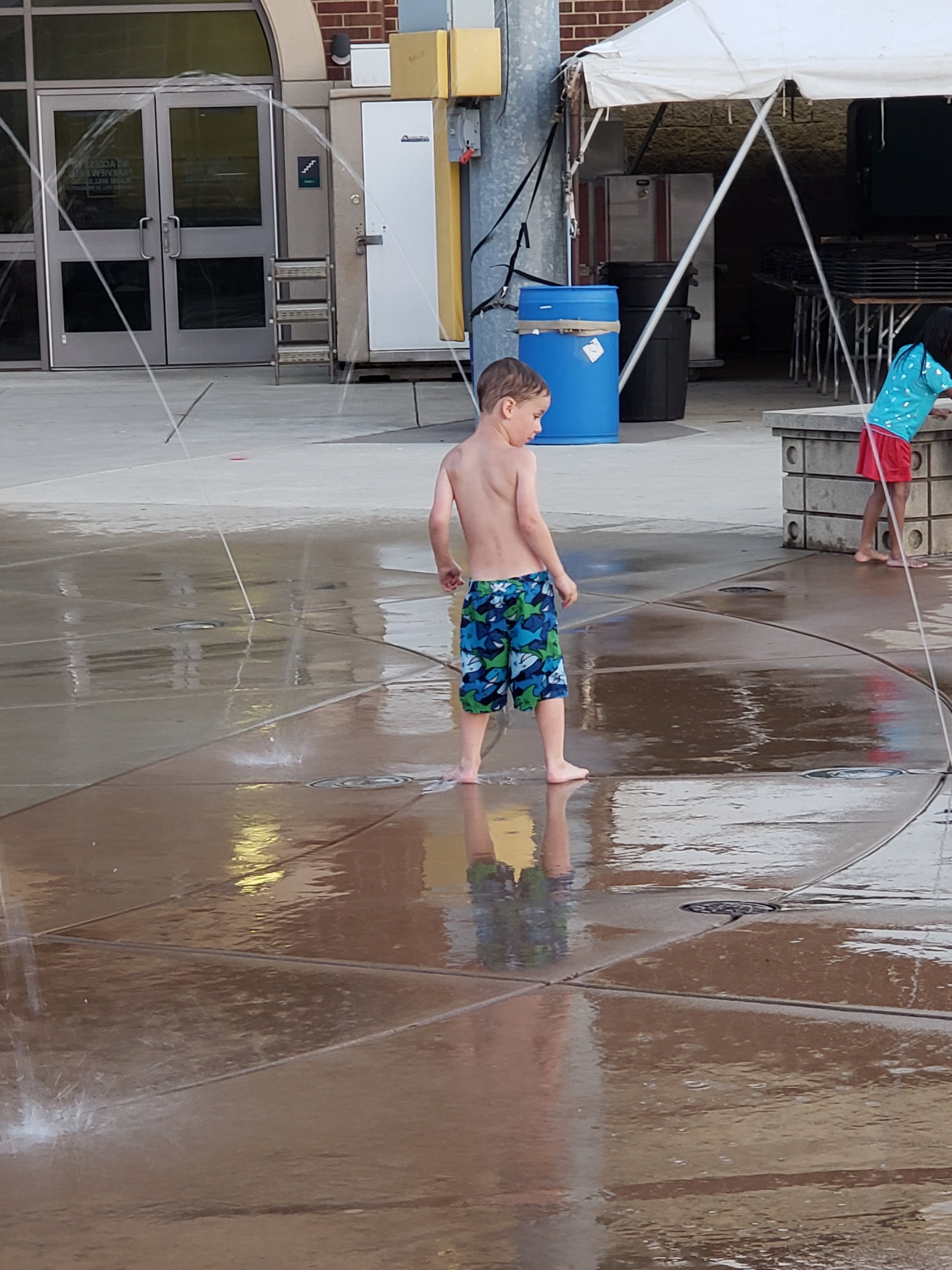 boy playing a a splash park