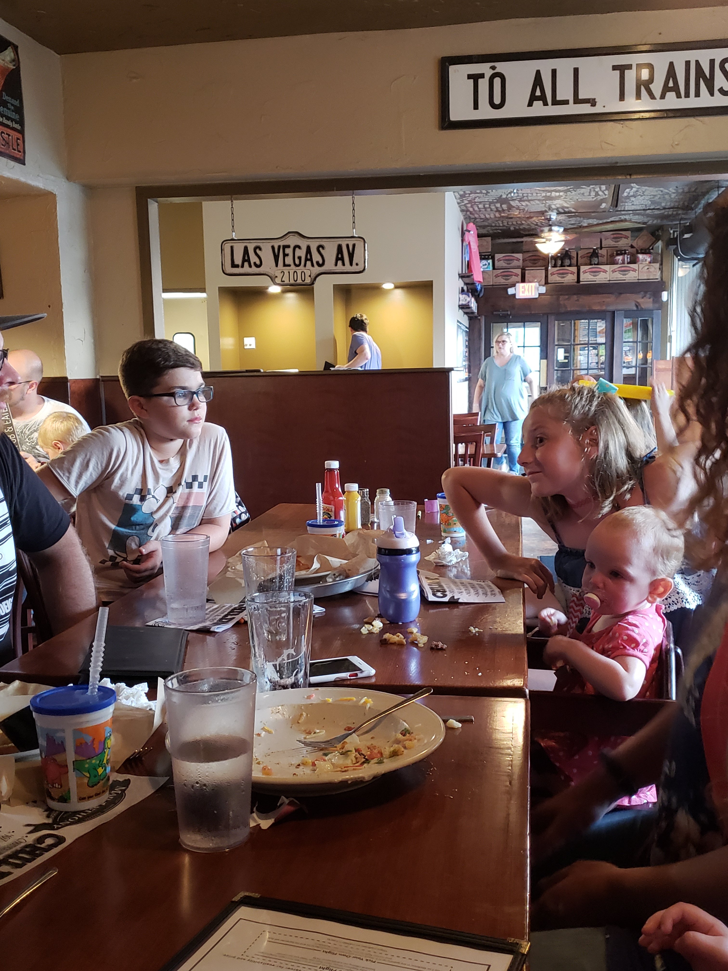 two dinning tables pushed together with 3 children sitting at the tables