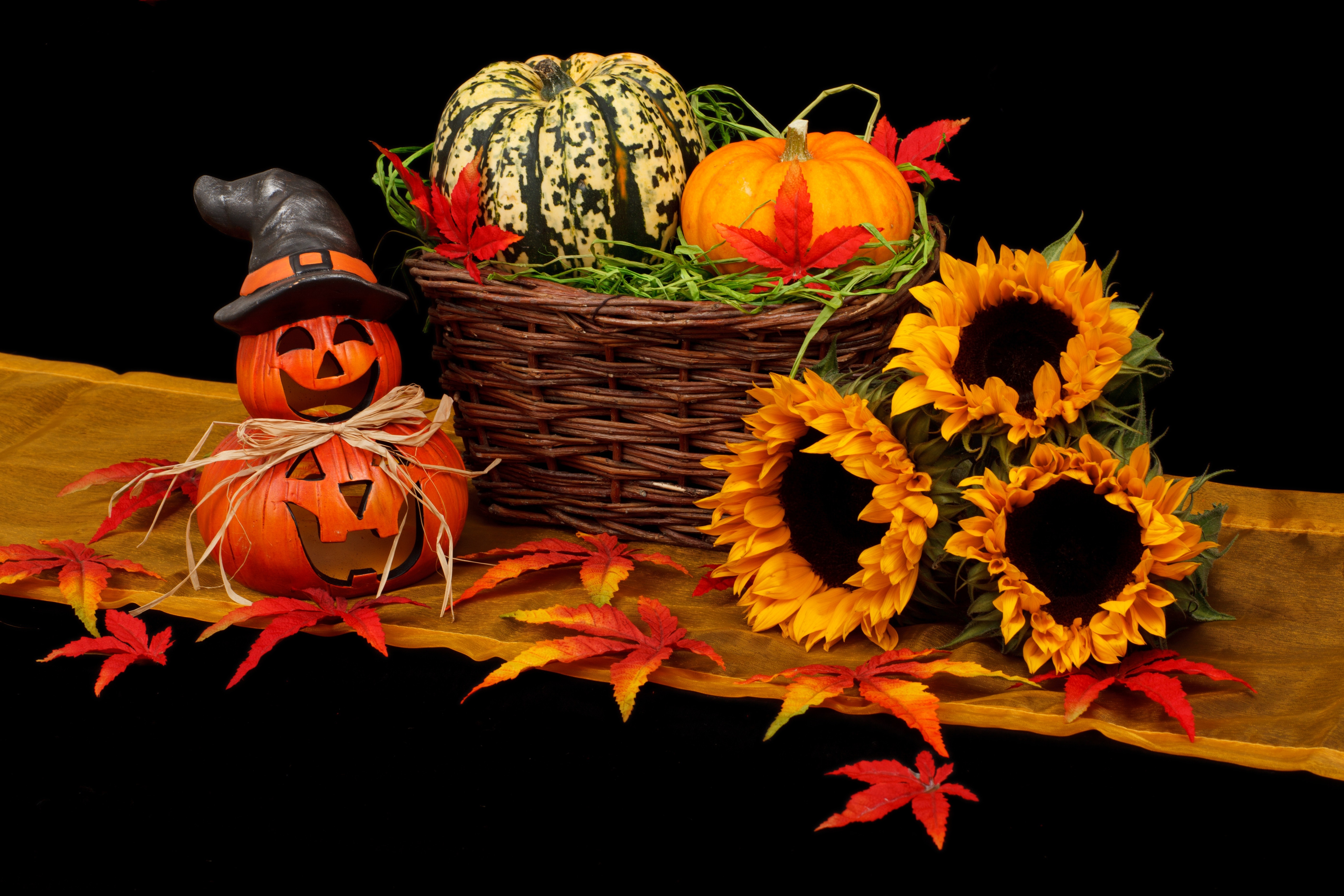 autumn table decorations - yellow runner, basket with small pumpkins in it, sunflowers 