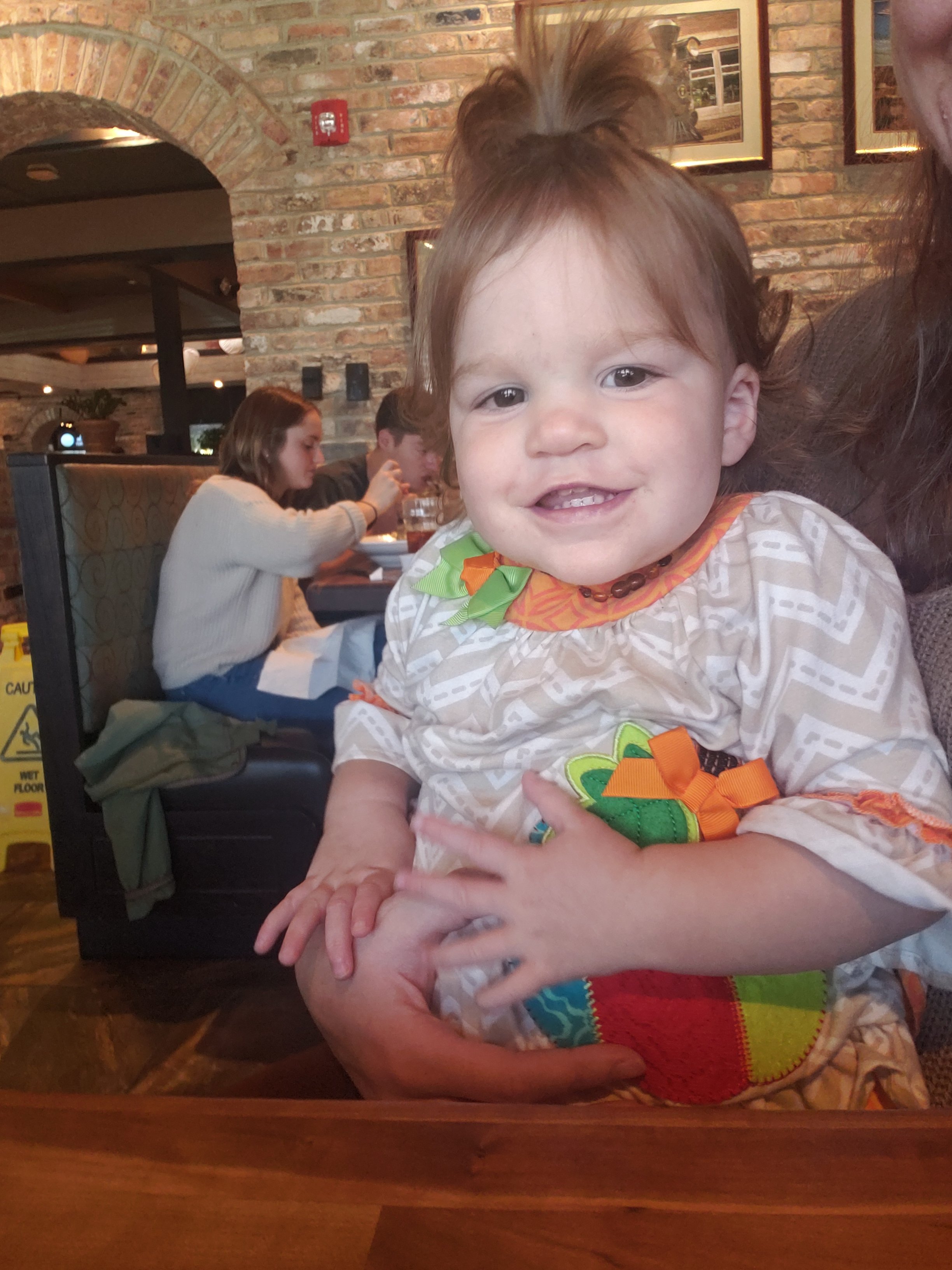 a woman holding a child on her lap in a restaurant 