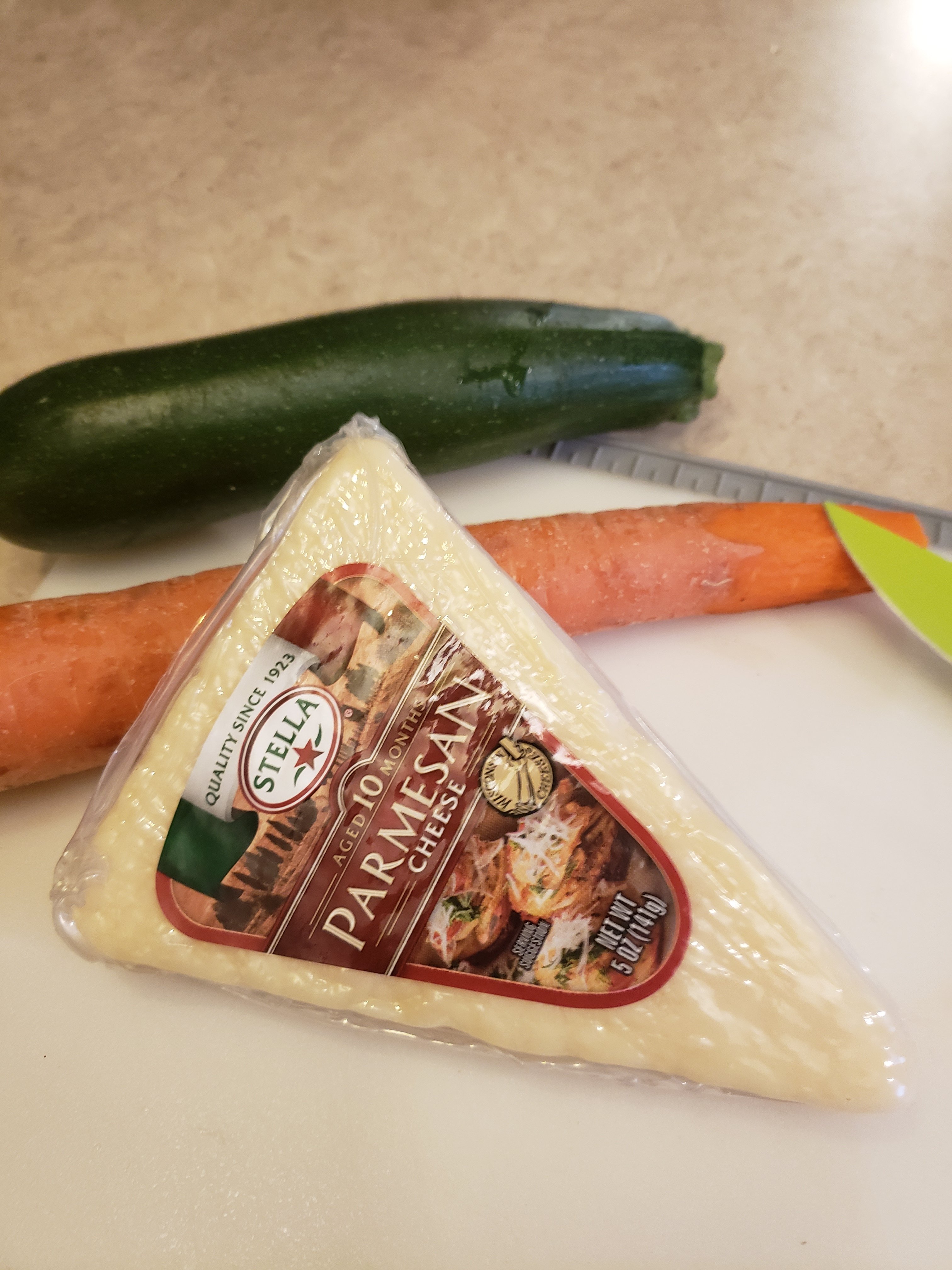 zucchini, carrot and Stella Parmesan cheese on a cutting board