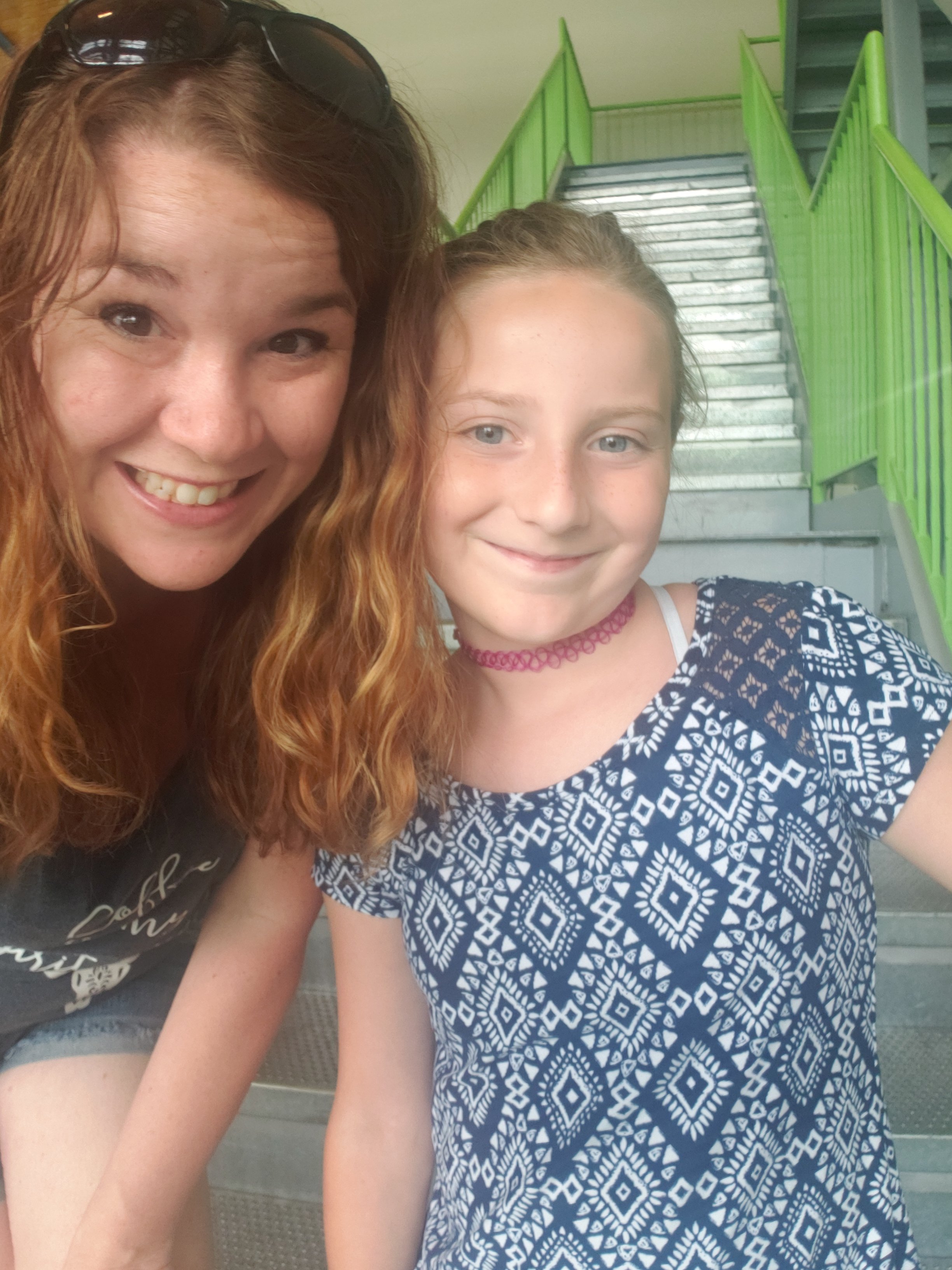 mom and preteen in front of a set of metal stairs