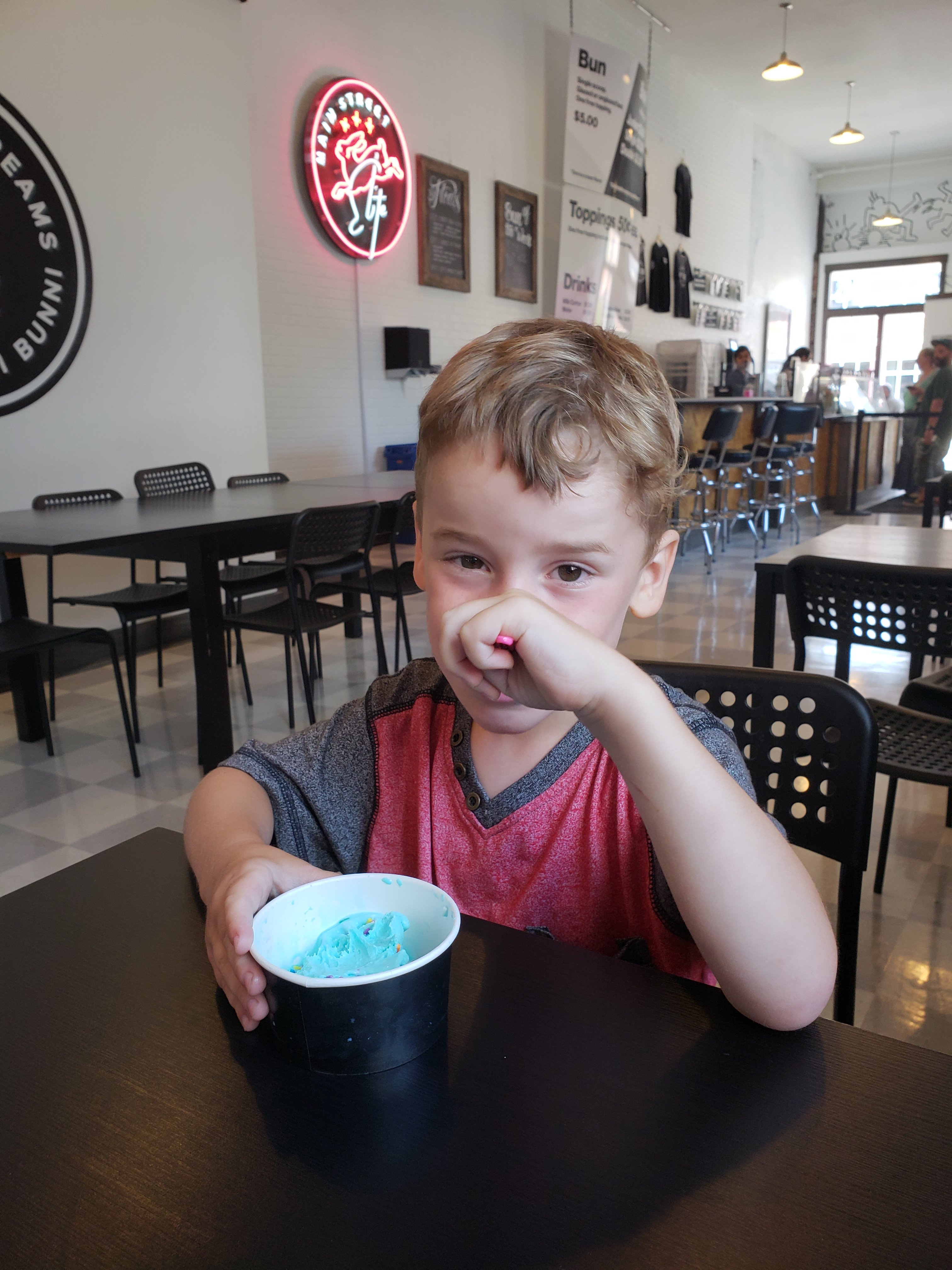 young boy eating a blue ice cream from 