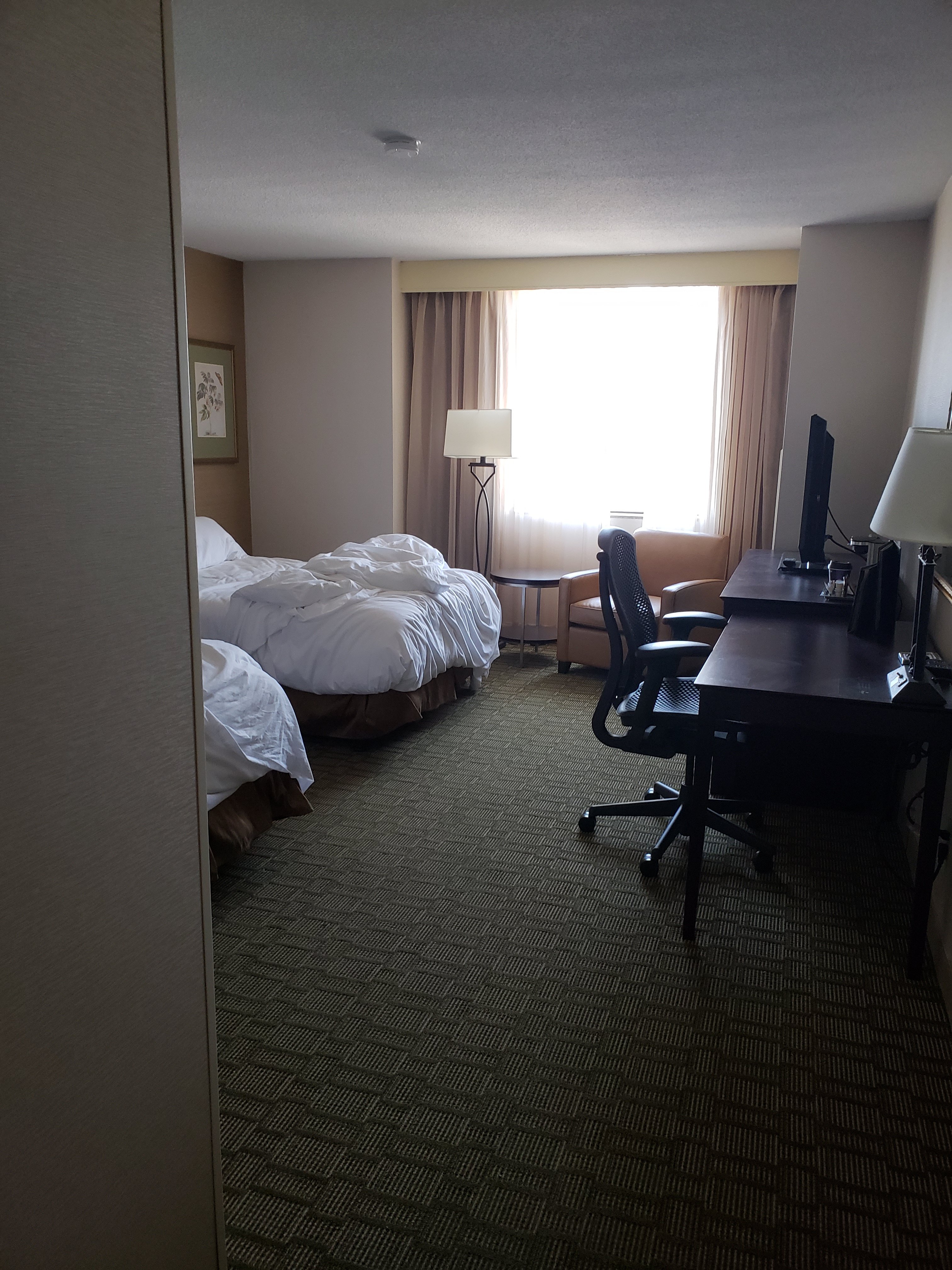 a room with 2 double bed and a desk in the The Hilton Downtown