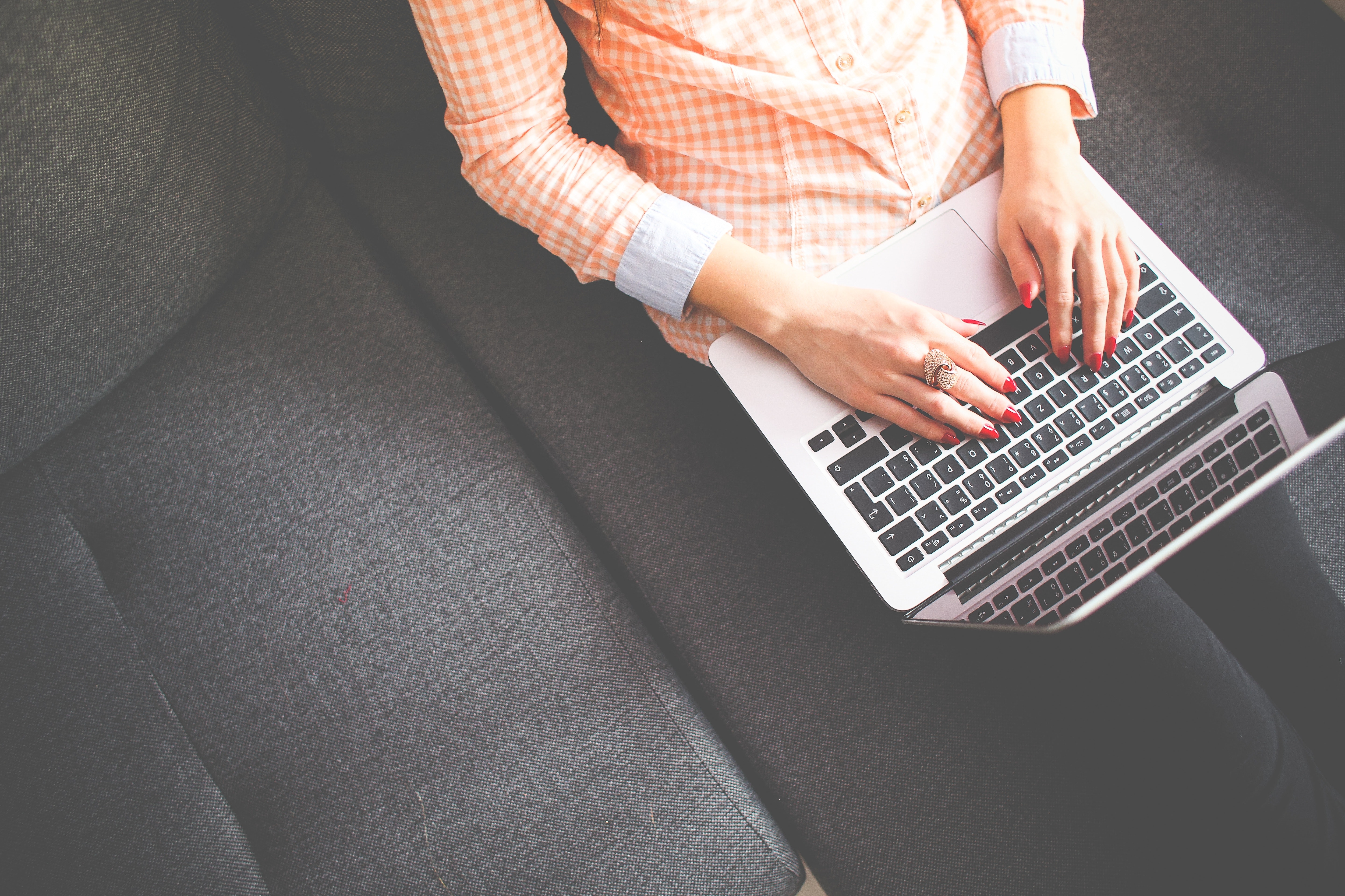 woman sitting on a couch with a laptop in her lap