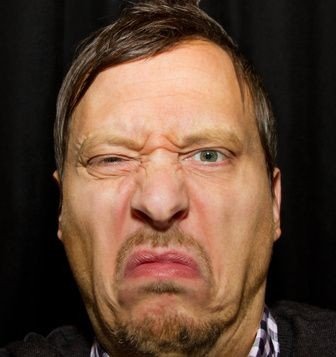 close up of a man's face, he's making a funny face at the camera