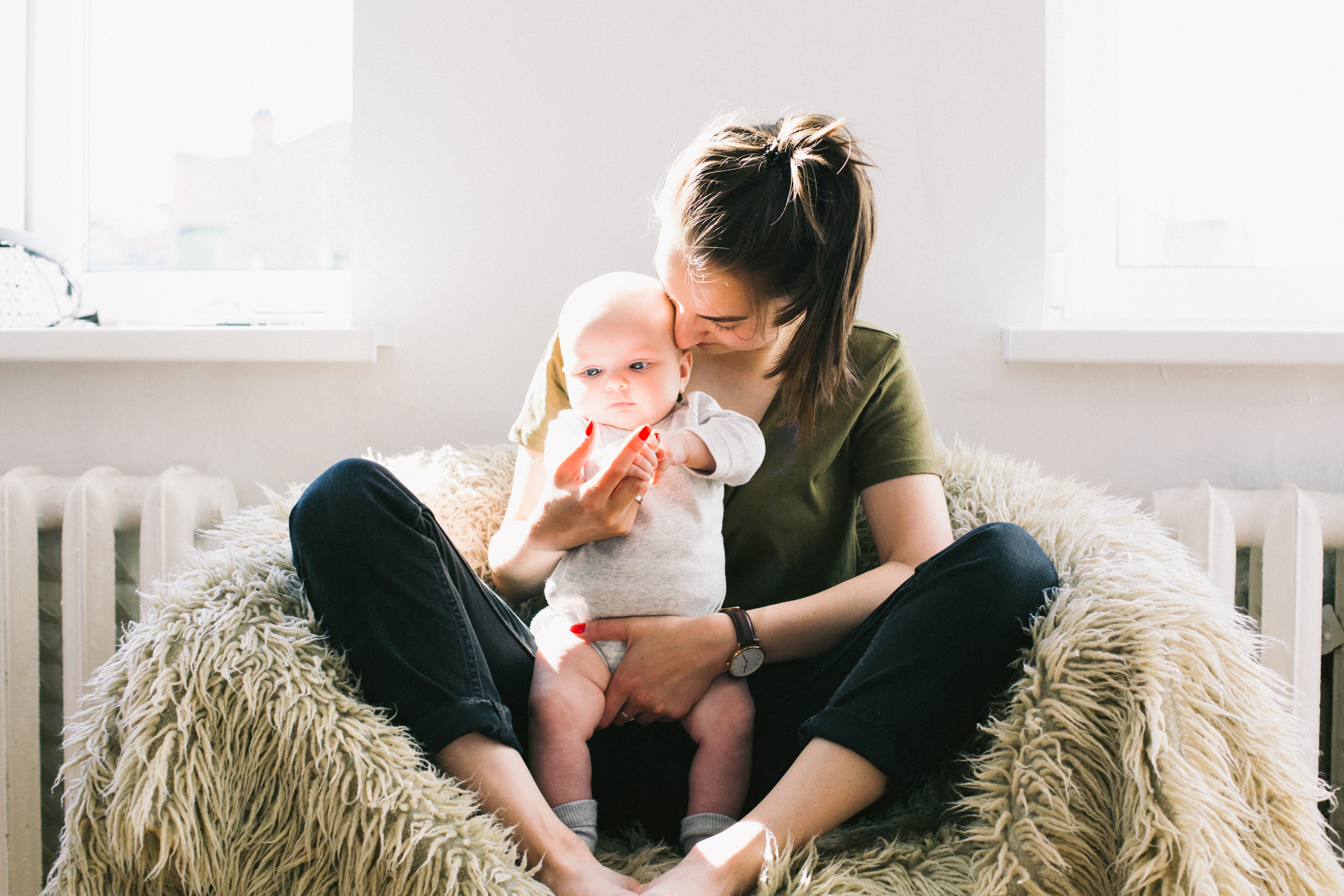 woman sitting in an oversized chair with an infant