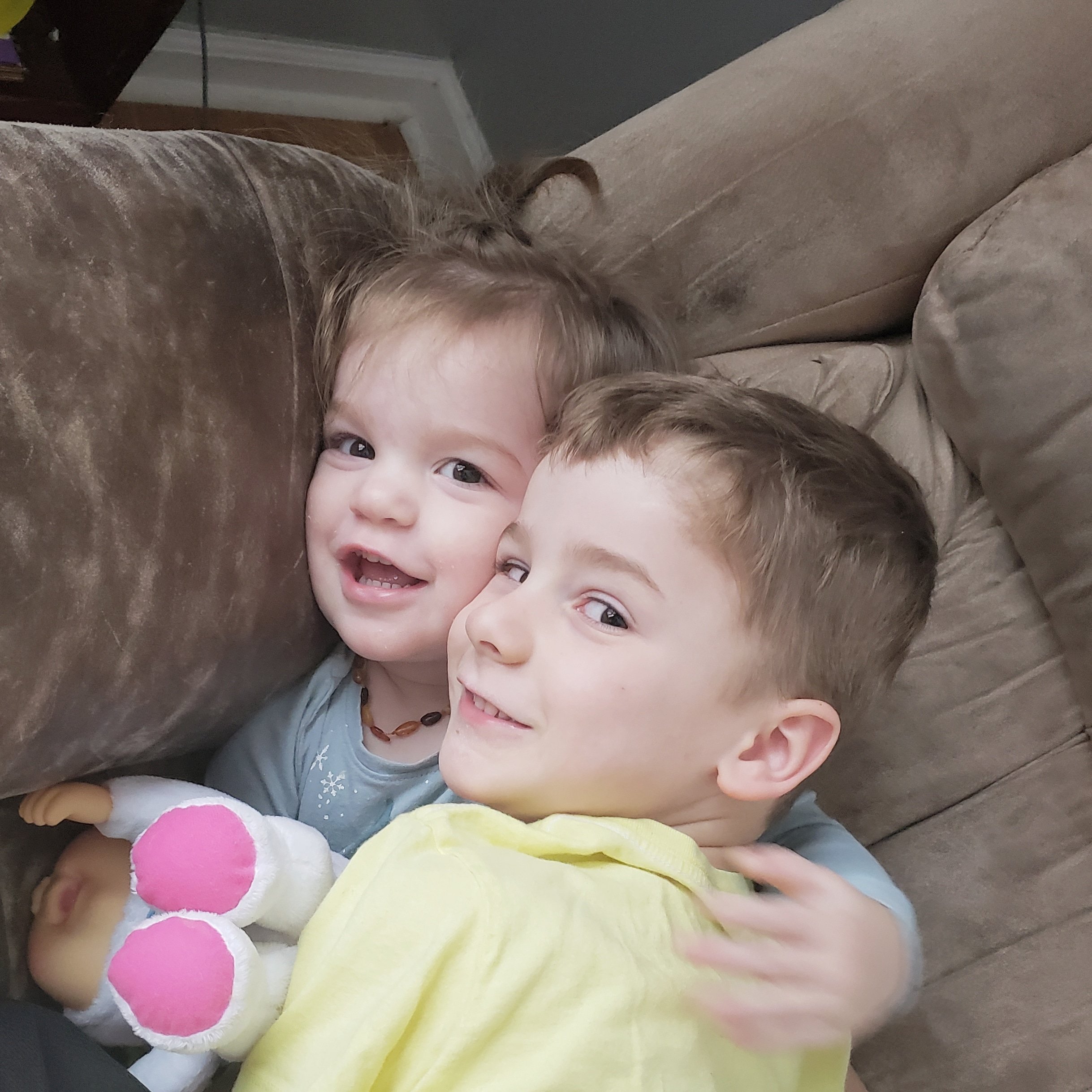 boy and toddler girls laying together on a couch