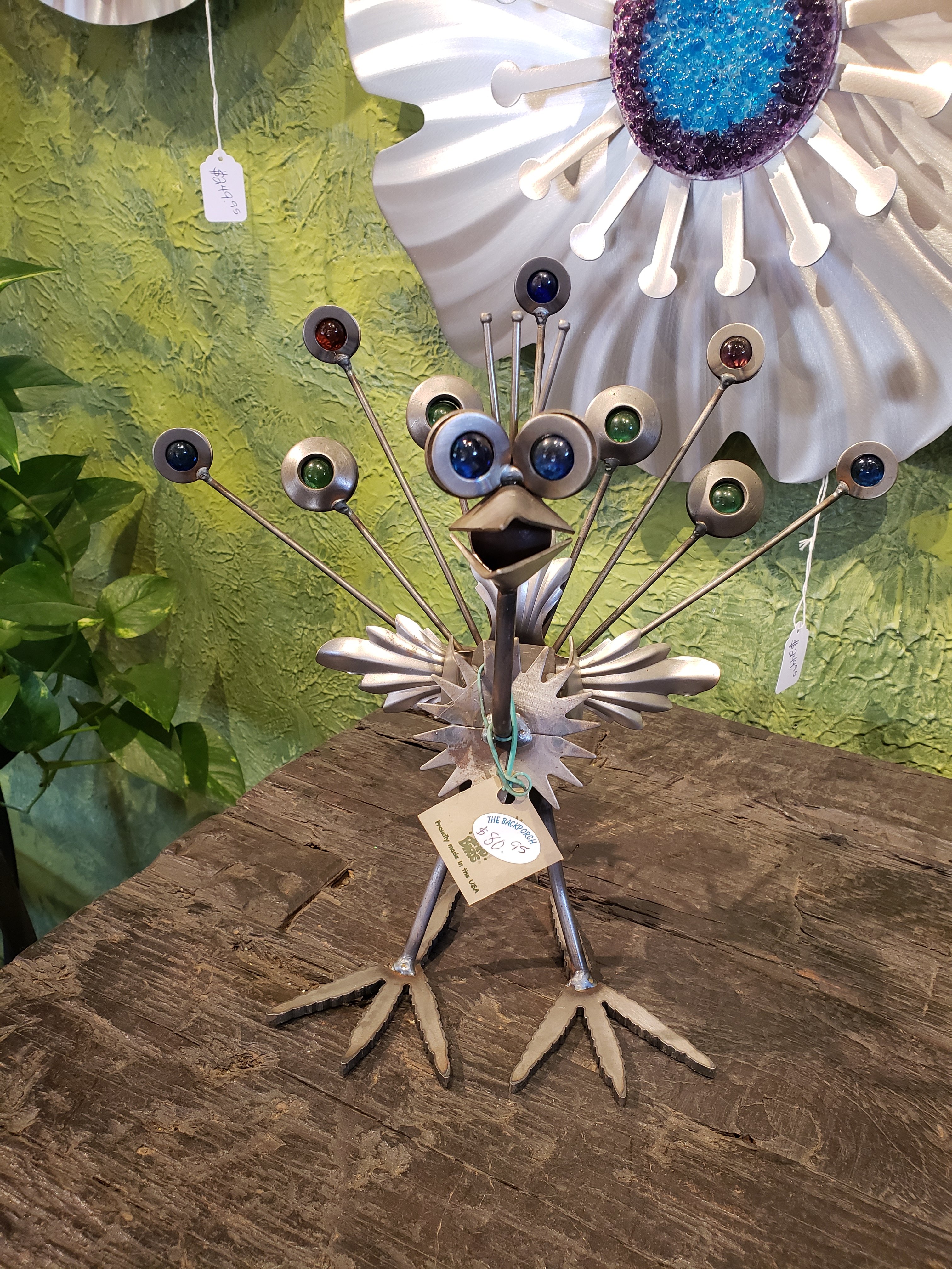 A boutique find, a metal and gem peacock sculpture on a wooden table