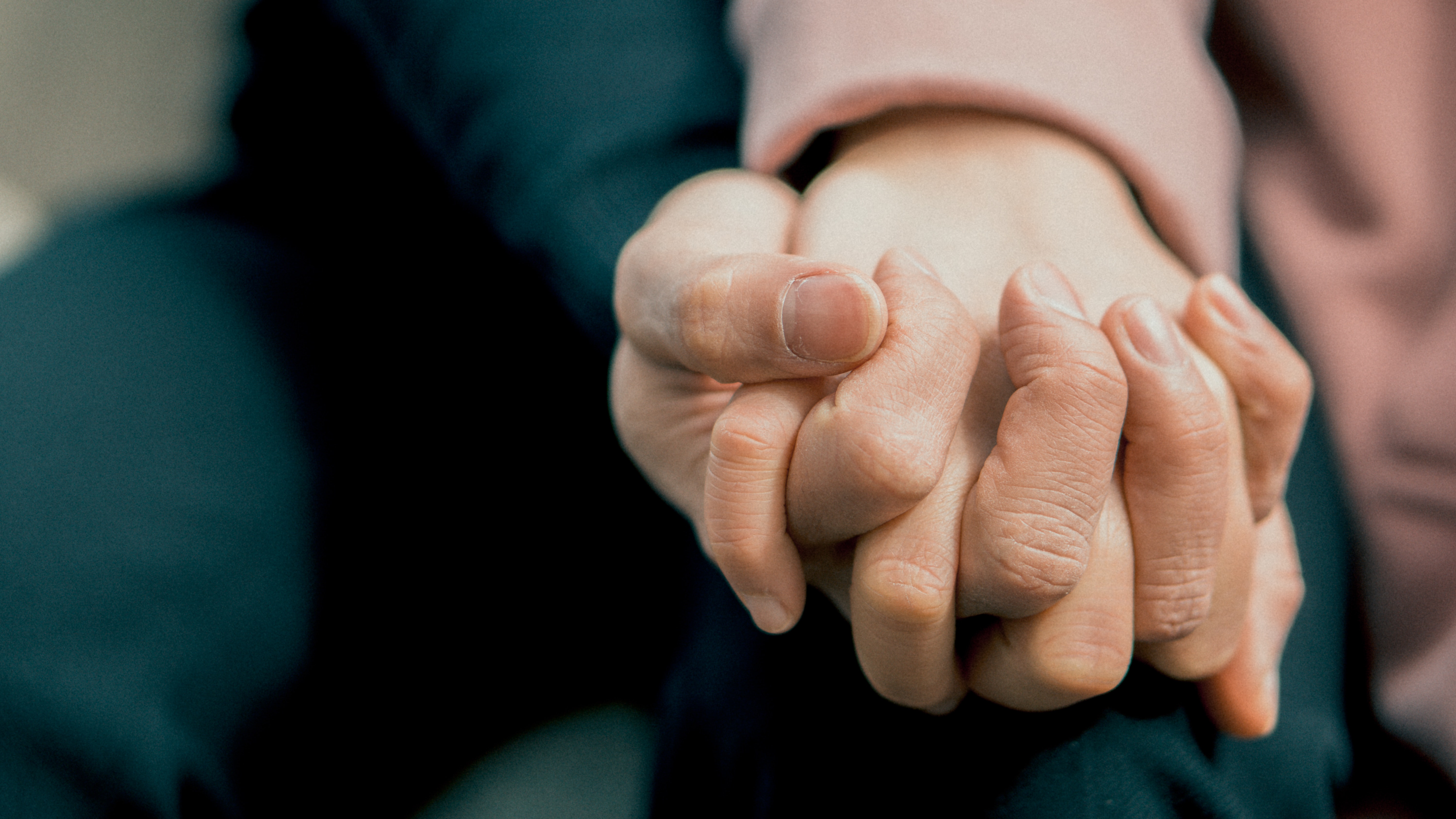 a close up of two people holding hands