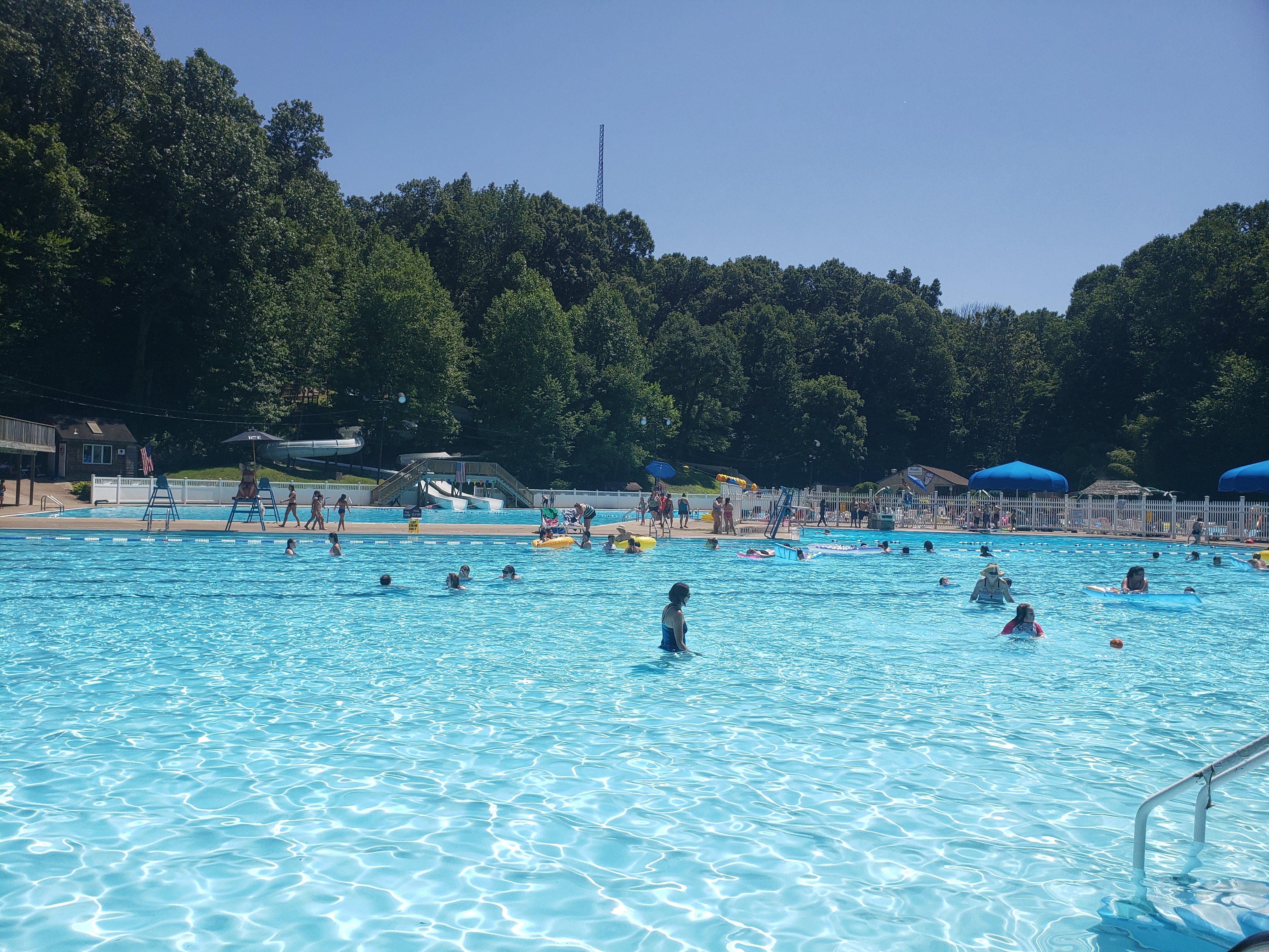 large blue pool with people swimming in