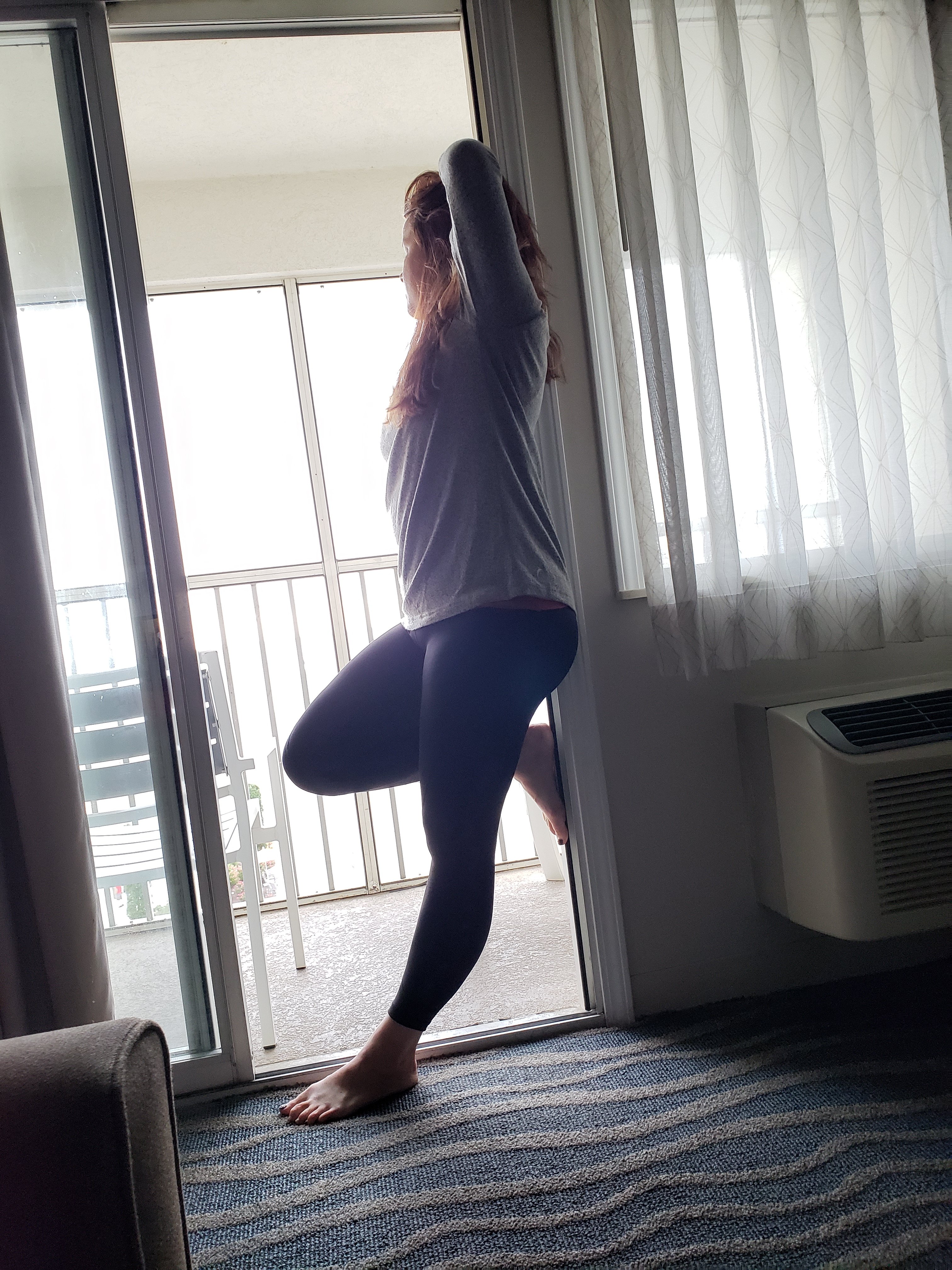 mom leaning back in an open patio door wearing leggings