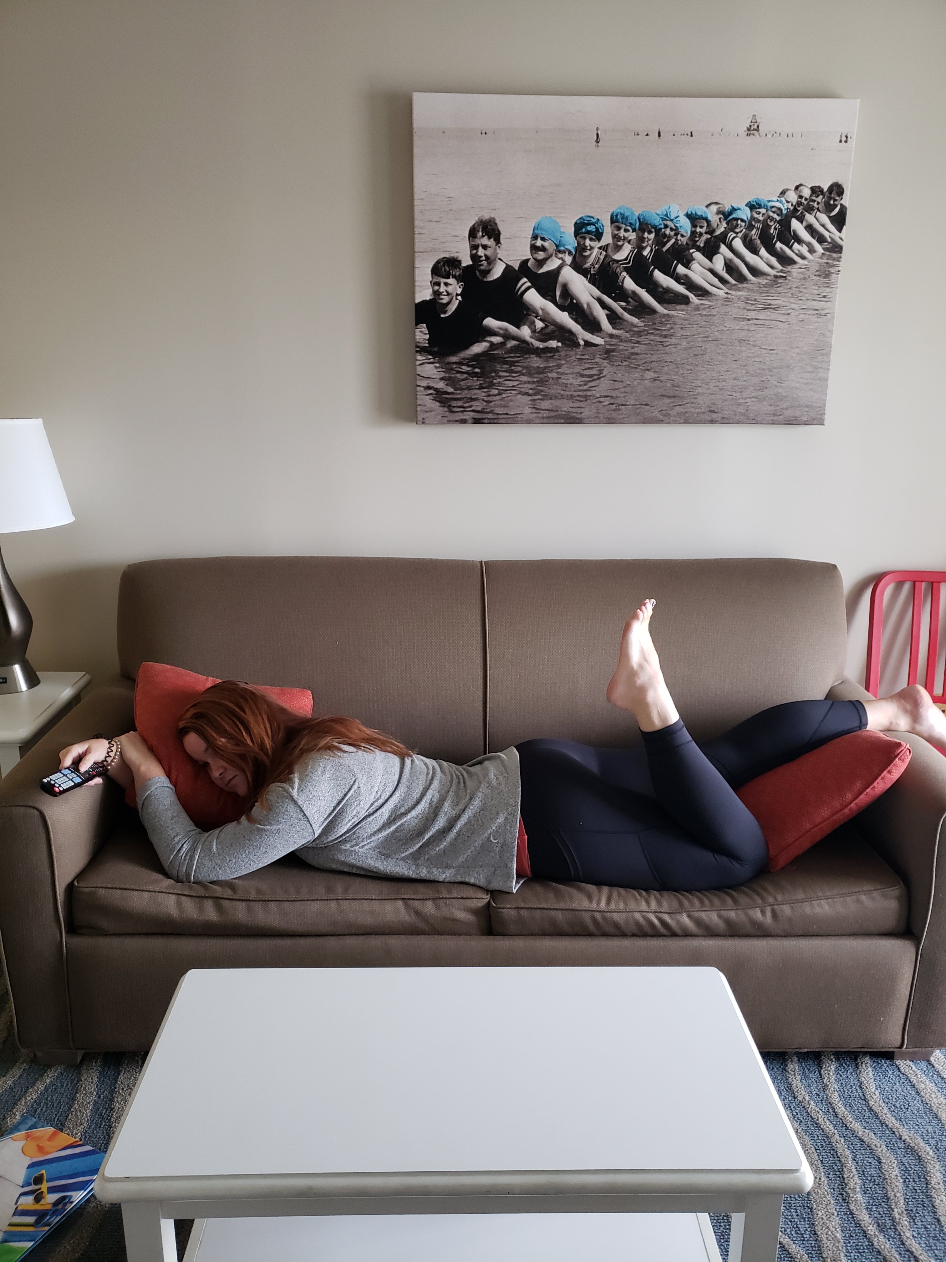 Mom laying on the couch with a tv remote wearing comfy clothes