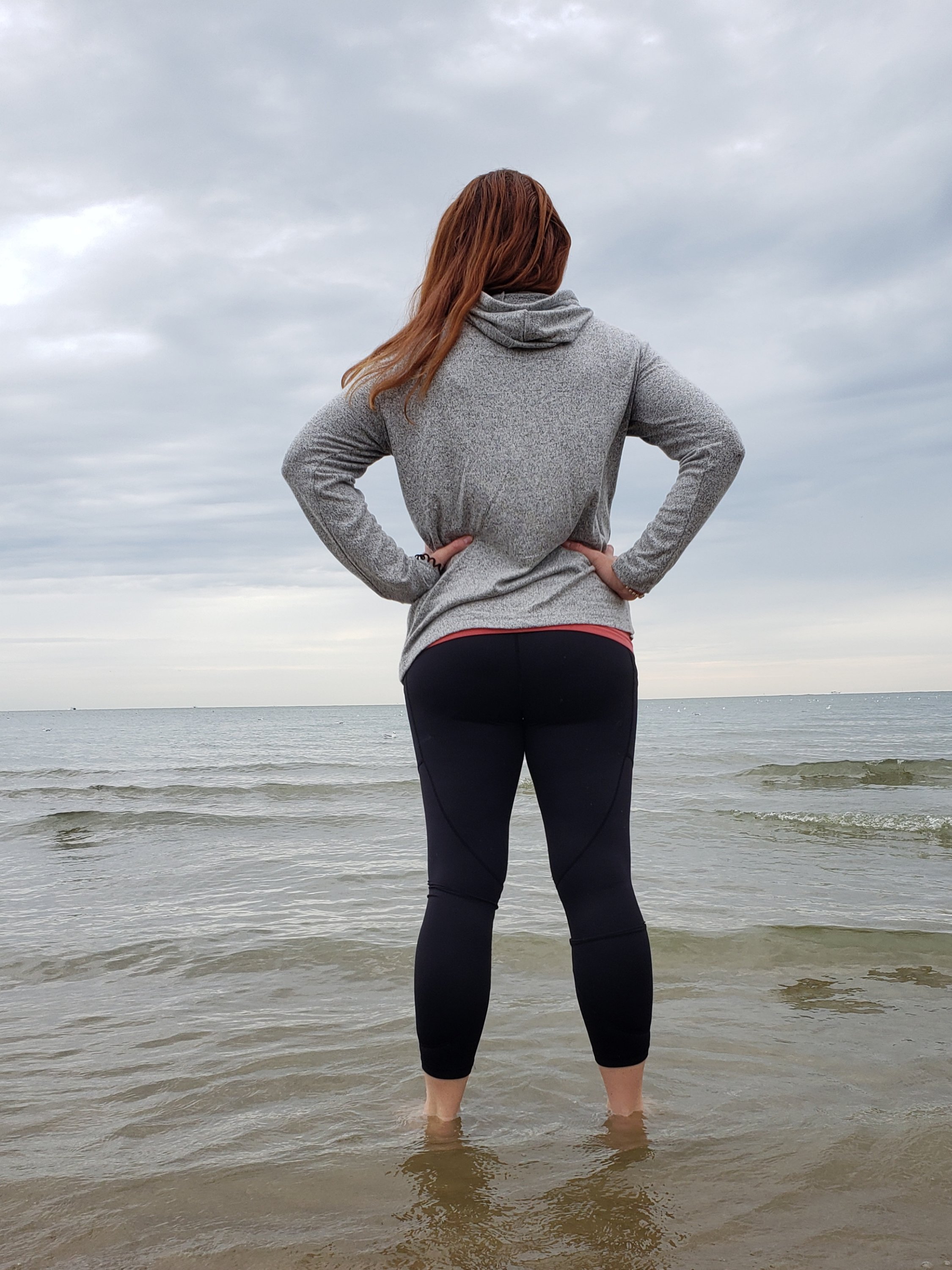 woman wearing ZYIA outfit standing ankle deep in the ocean